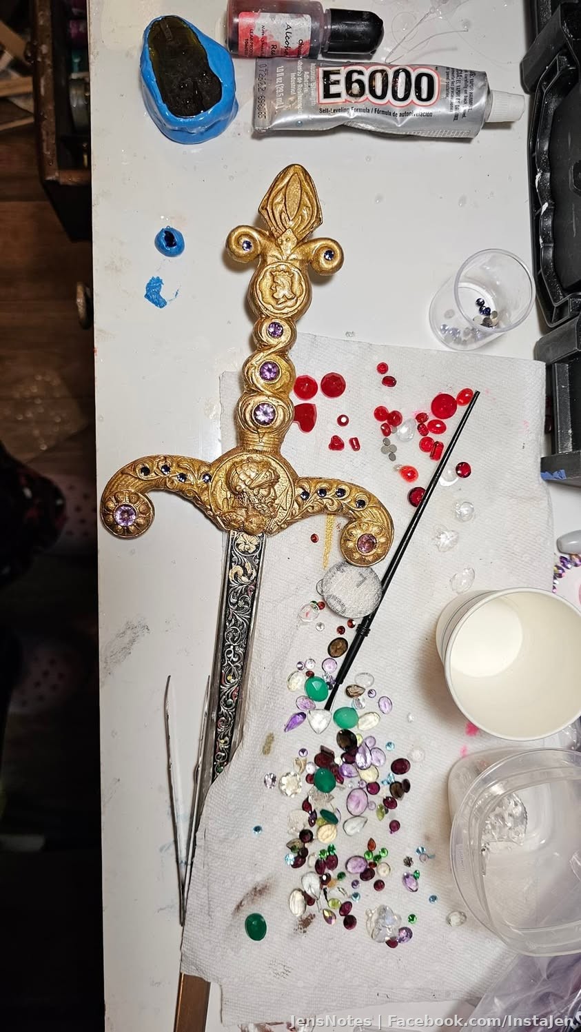 Working on the handle of this one sword decorating it with real gold liquid leafing and faceted tanzanite!